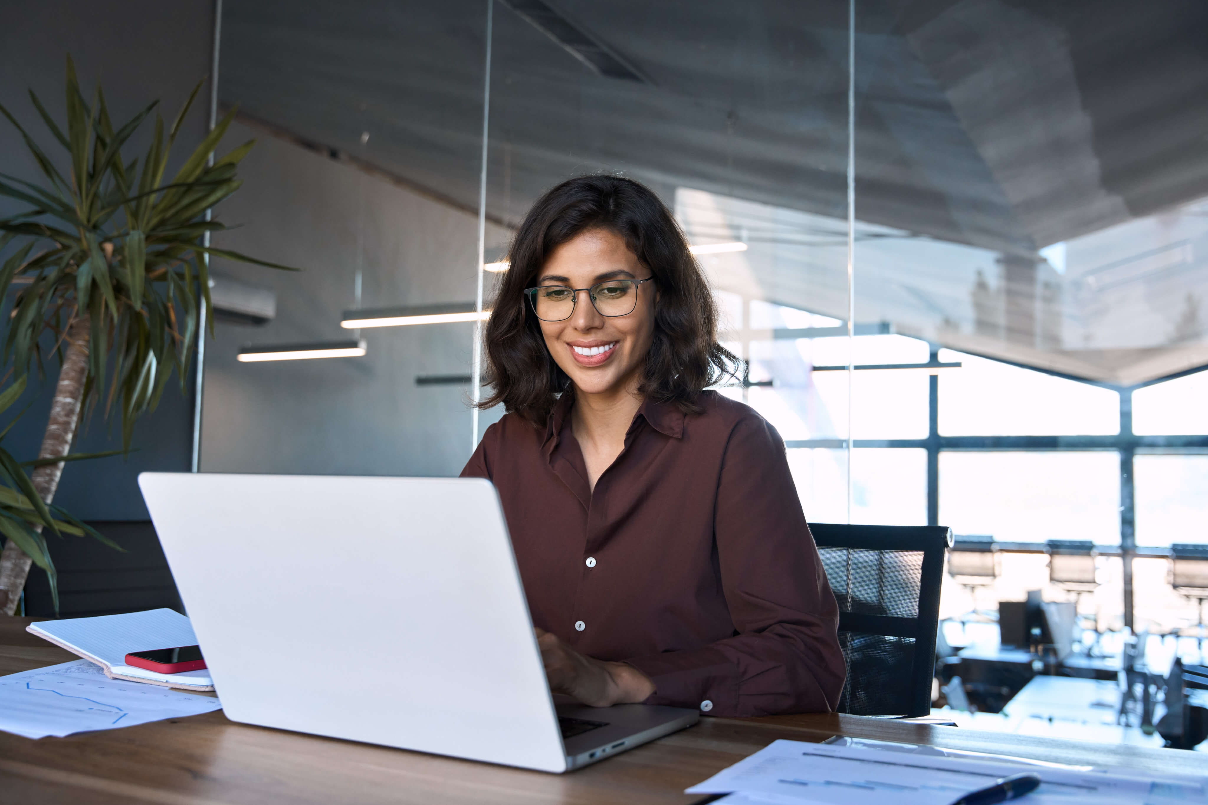 A smiling woman sitting at a laptop