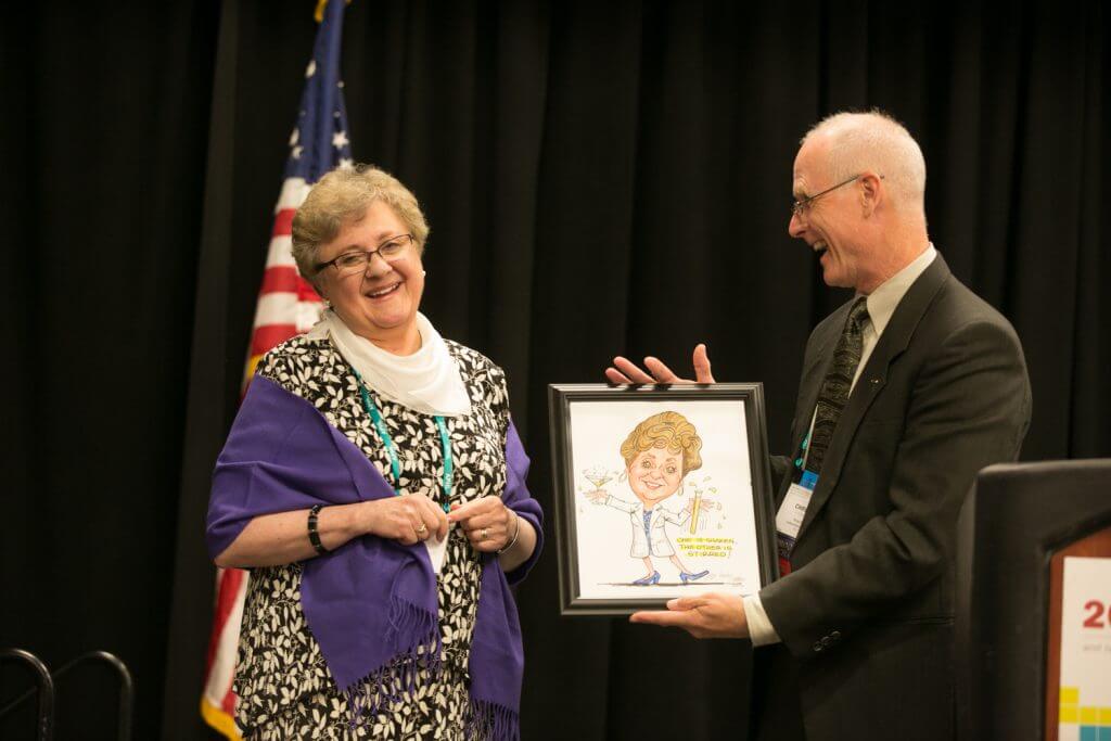 In-coming board president, Chris Whelen, gives Judy Lovchik, past president, a parting-gift