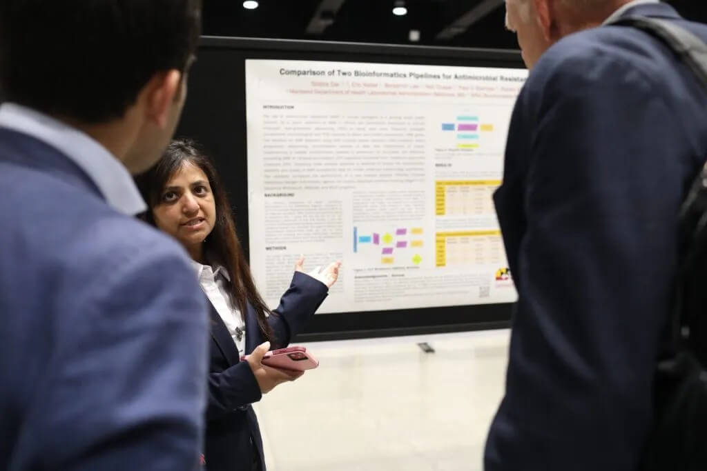 Attendees view and discuss a poster.