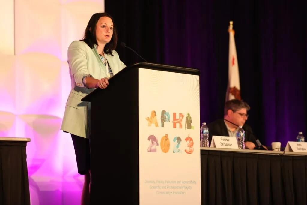 A speaker stands at a podium at the 2023 APHL Annual Conference