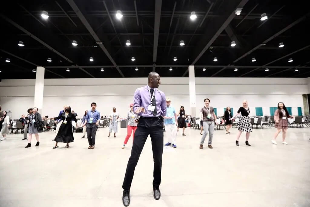An APHL staff person leads attendees in line dancing