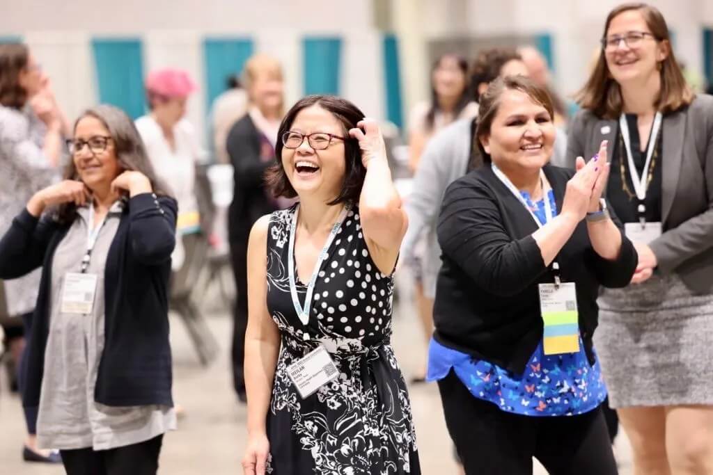 Attendees smile and laugh.