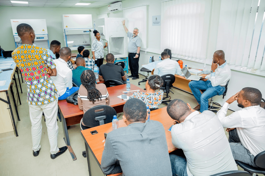 Training participants listen as a course developer provides broader context during hands-on session during a biological safety cabinet certification training in Tanzania.