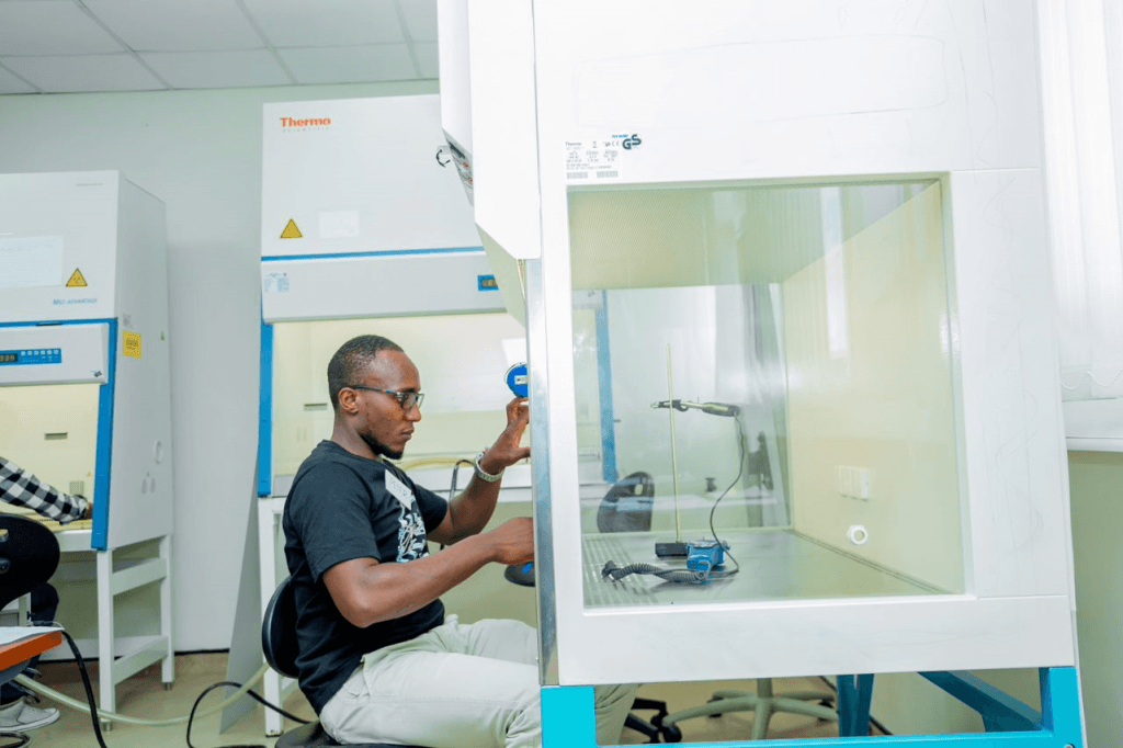 A field certifier from Uganda takes measurements of a biological safety cabinet during the NSF accreditation practical test.