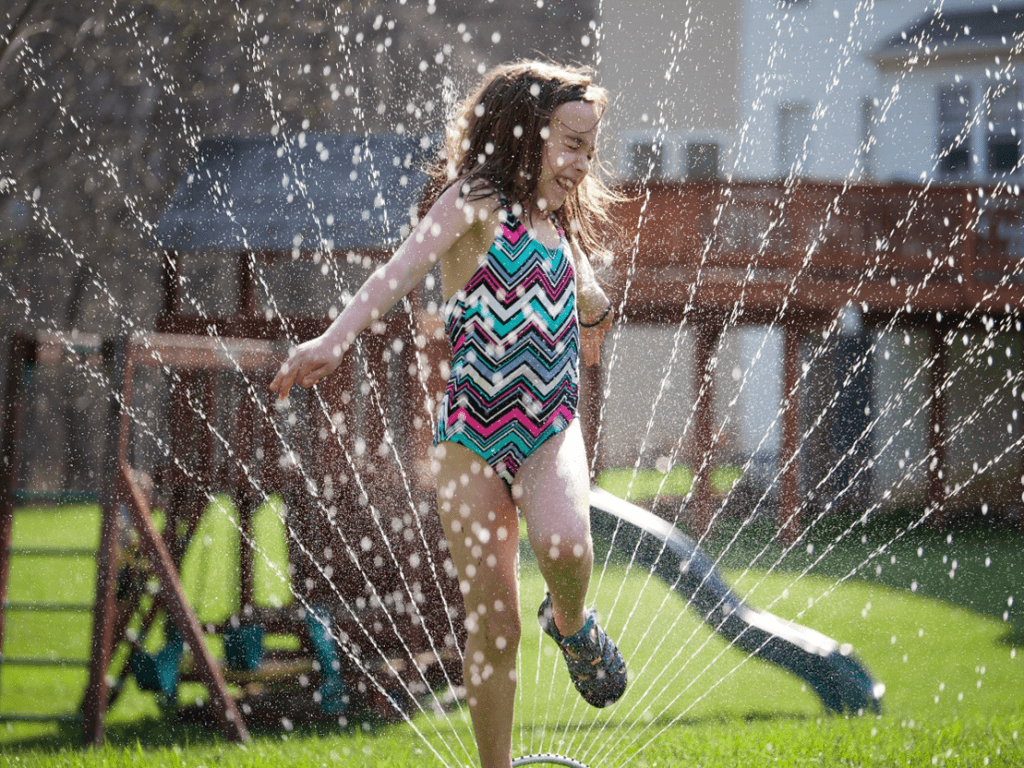 Photo of a child running through a water sprinkler