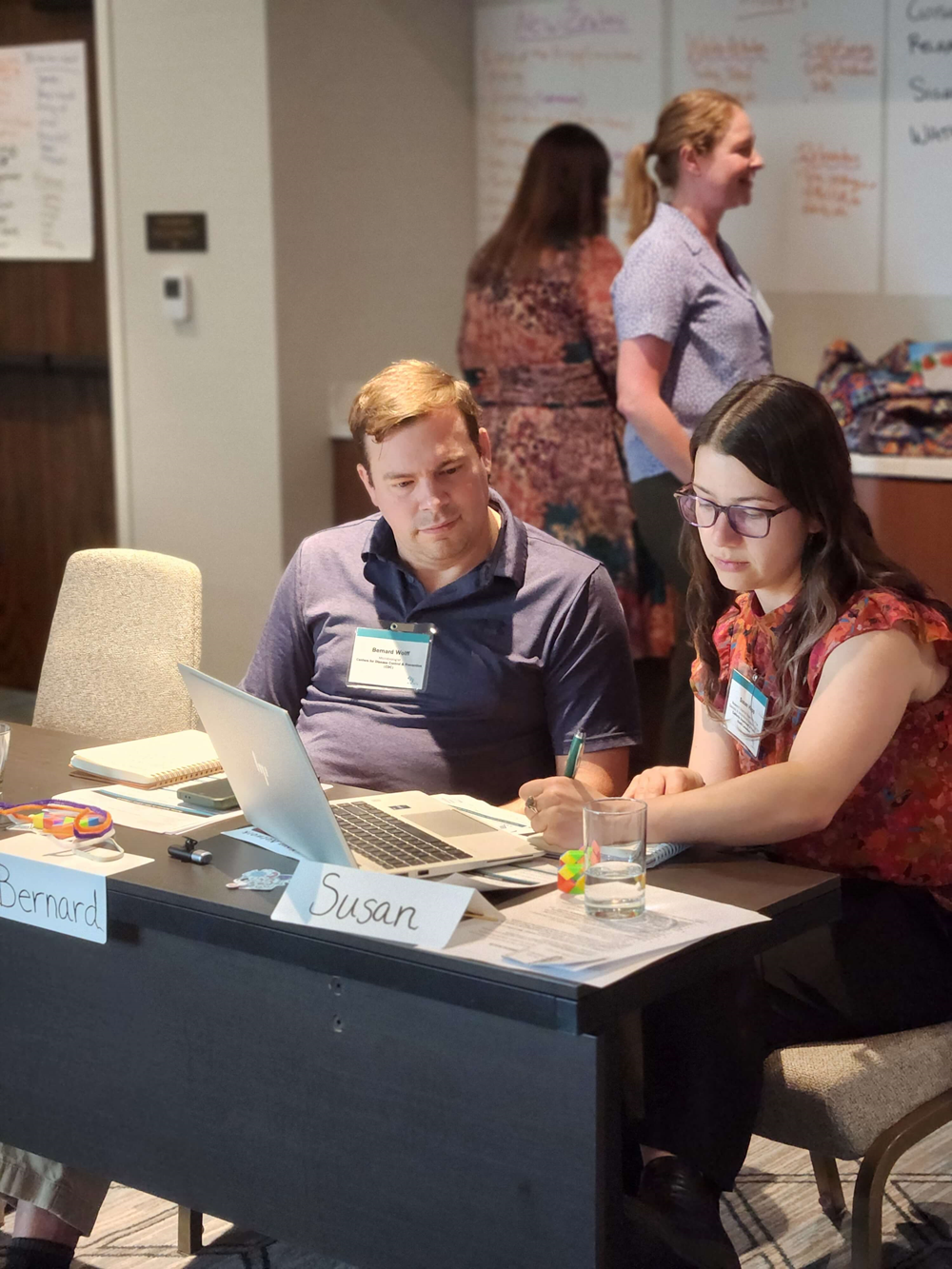 : ELP Cohort 19 (Hybrid Modality) members work together preparing to lead an effective meeting example for their cohort.