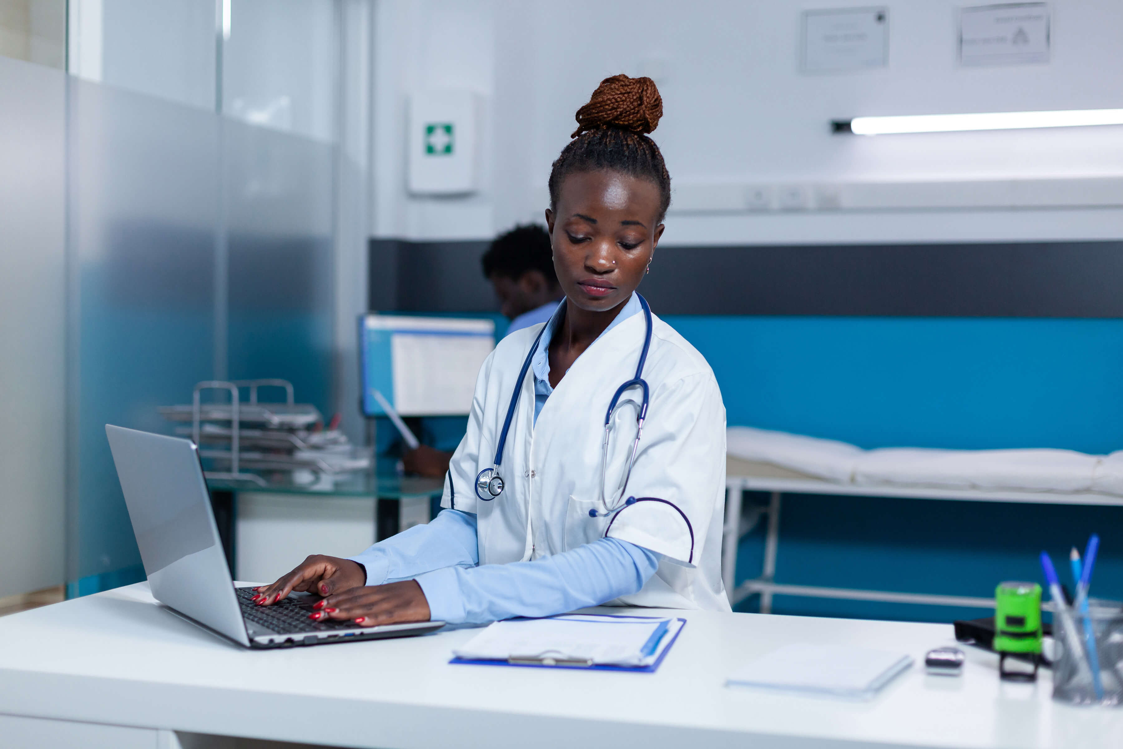 female healthcare worker works at computer doing data entry
