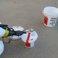North Dakota Public Health Laboratory staff use a handheld radiation detector to scan over-pack packaging for radiation during a drill